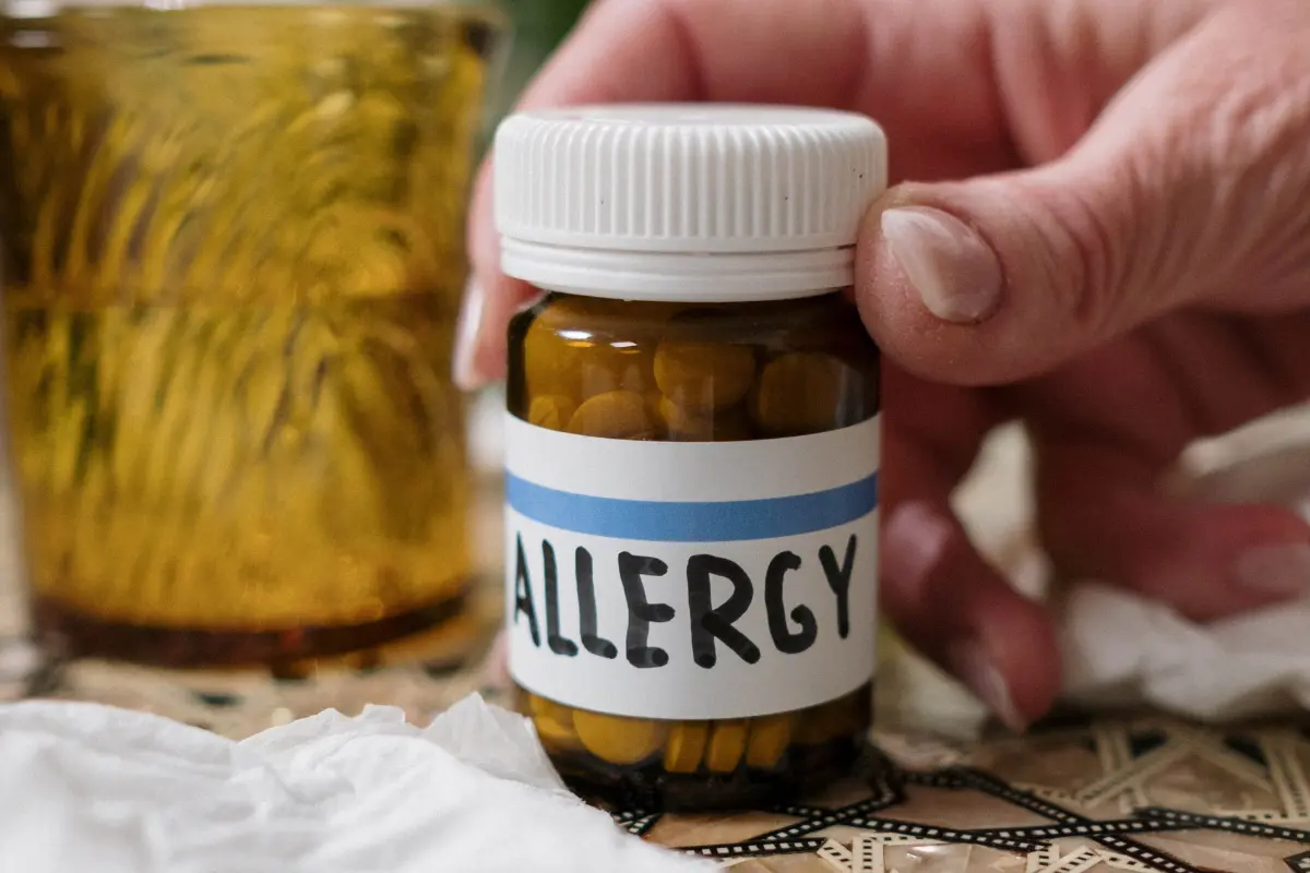 hand holding a bottle of allergy medicine.